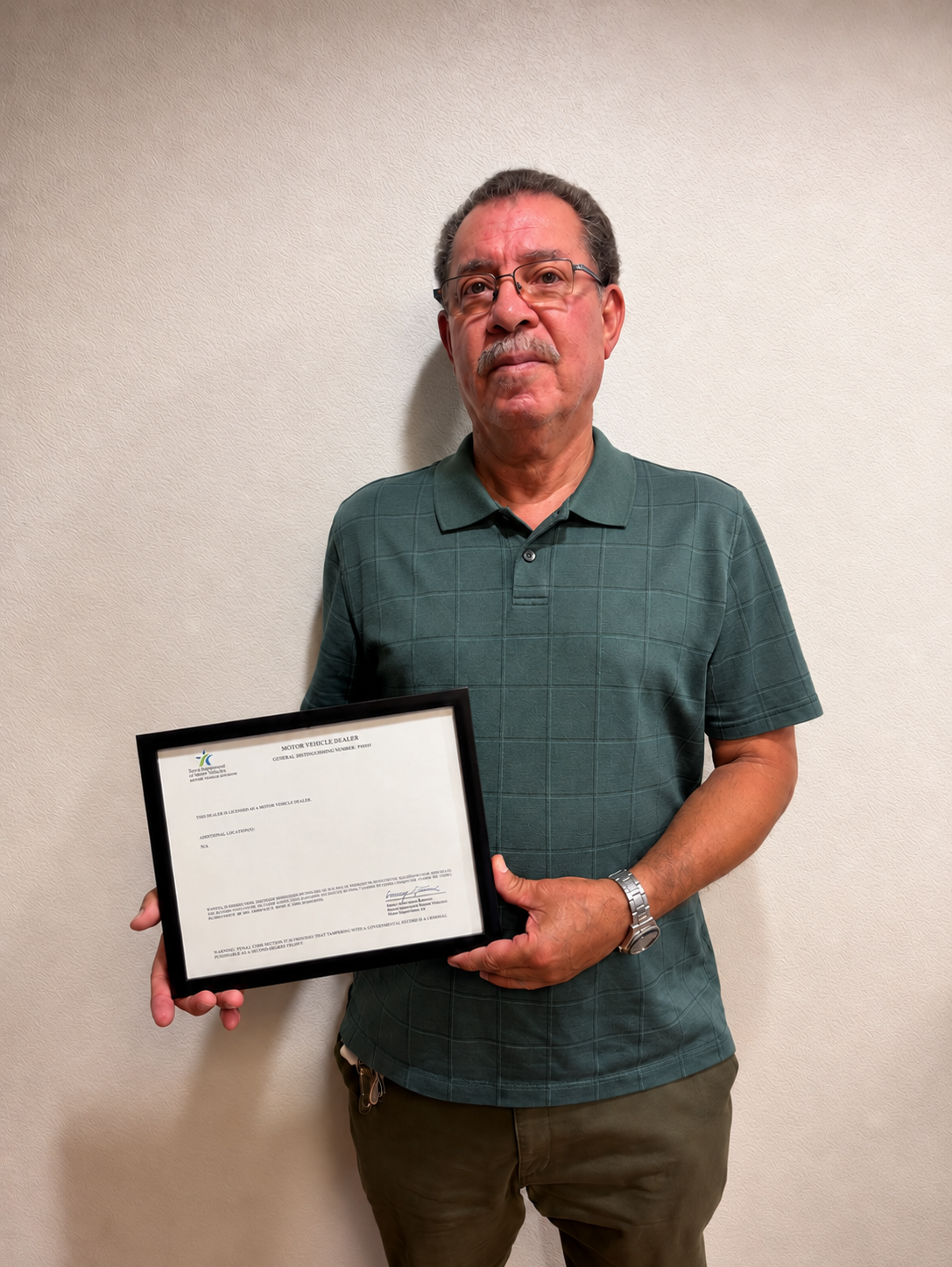 A client of Ricky Cabrera holding his approved motor vehicle dealer license
