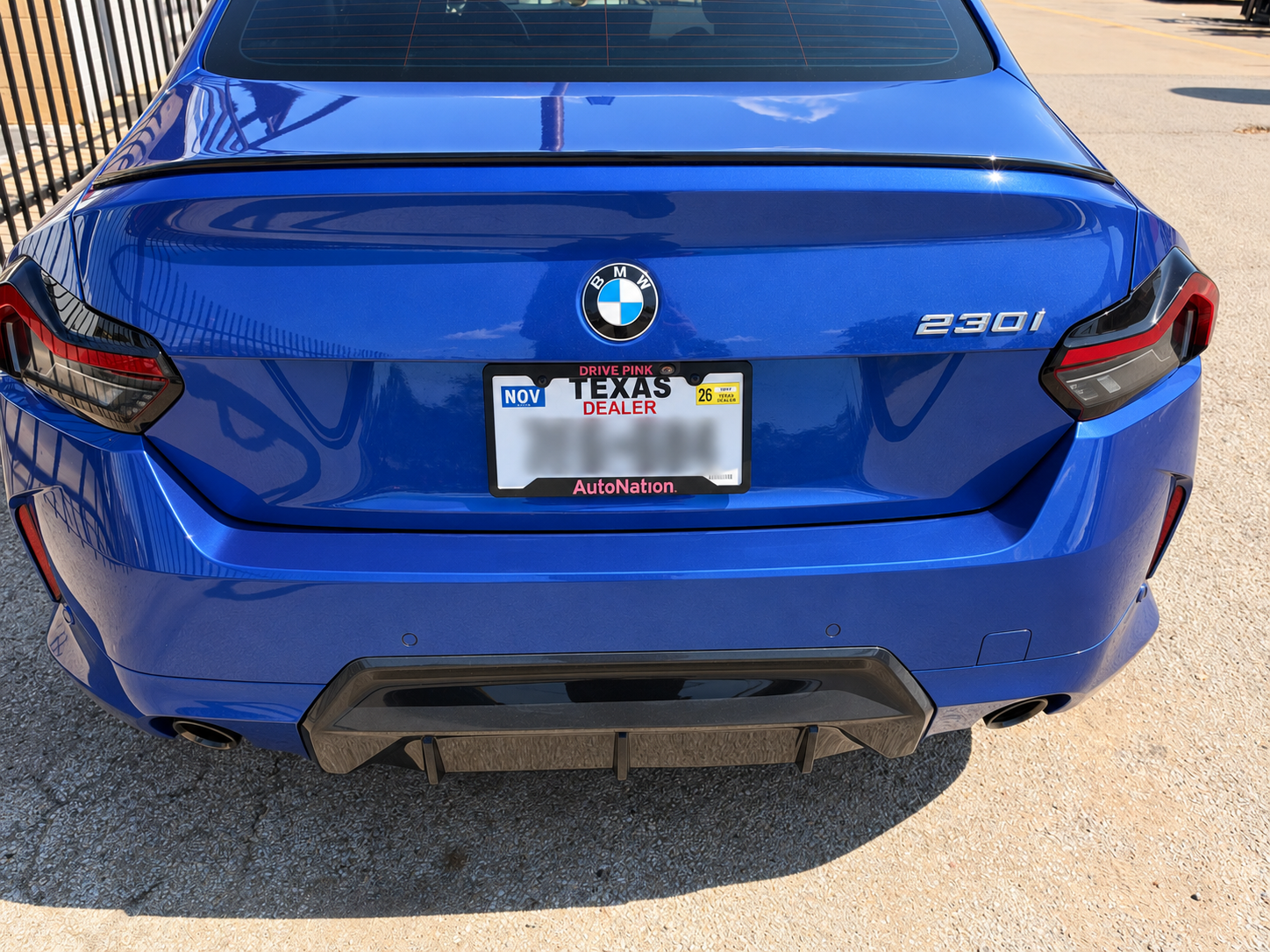 Blue BMW 230i displaying a Texas dealer plate